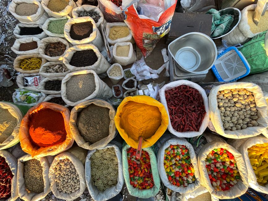 Top view of a vibrant assortment of spices in sacks at a market, displaying the colorful variety of ingredients.